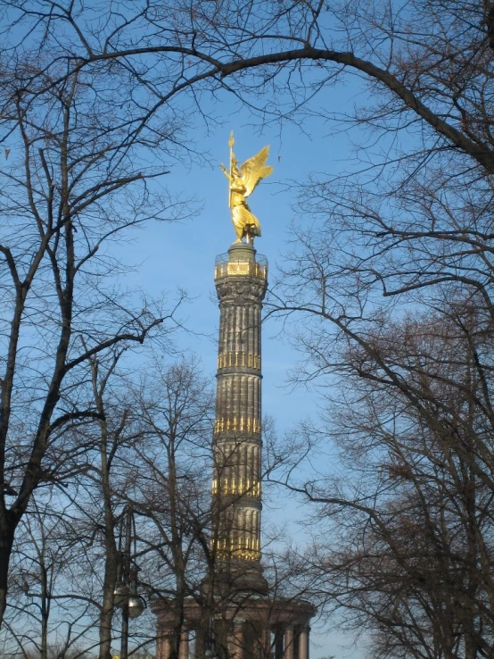 this is an image of a large building that has a gold angel statue on top