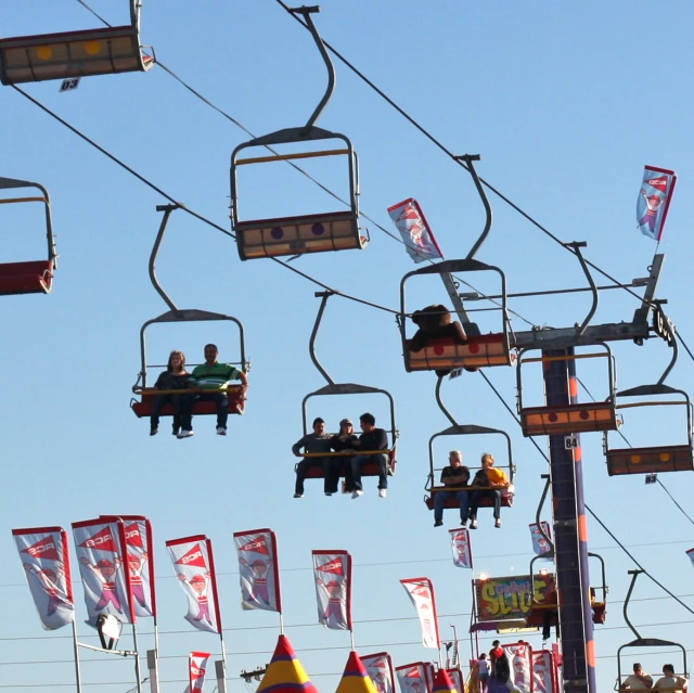 people riding a large cable car with two overhead stands