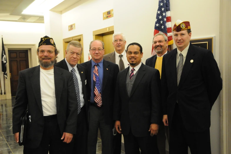 a group of business men in formal wear standing next to each other