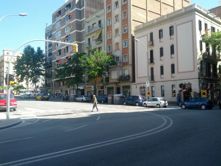 cars line up along the road next to a row of buildings