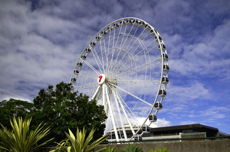 a ferris wheel under a blue sky on a cloudy day