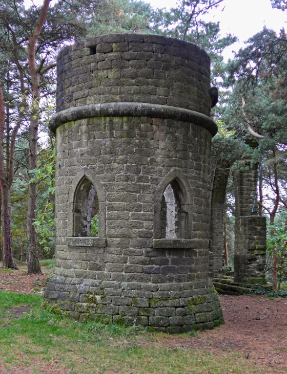 an old tower with two windows near trees
