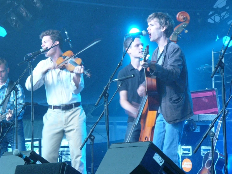 a concert where a group of men are singing and playing the violin