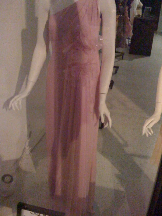 a pink dress on a mannequin in a window