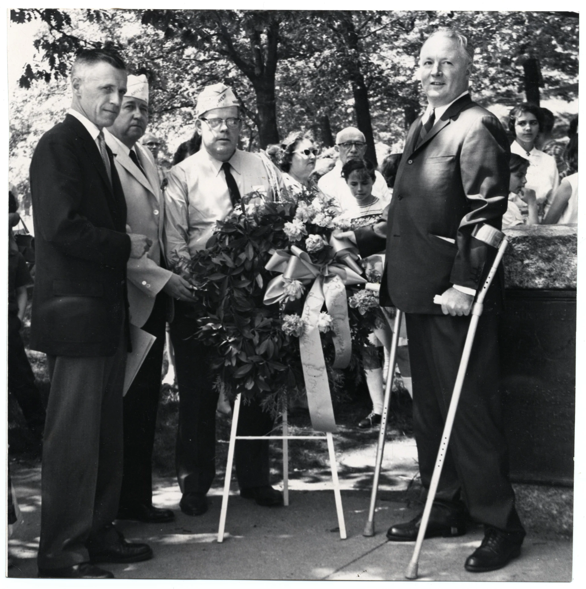 two men holding canes are smiling as others look on