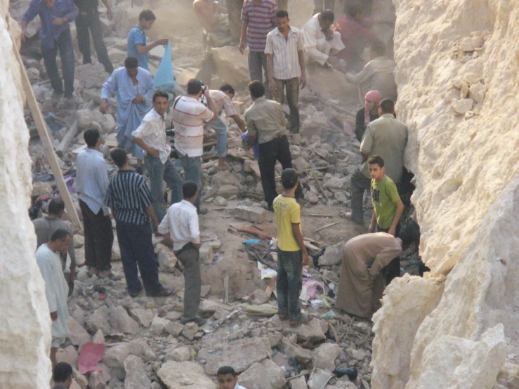 several people are digging and cleaning rubble at a construction site