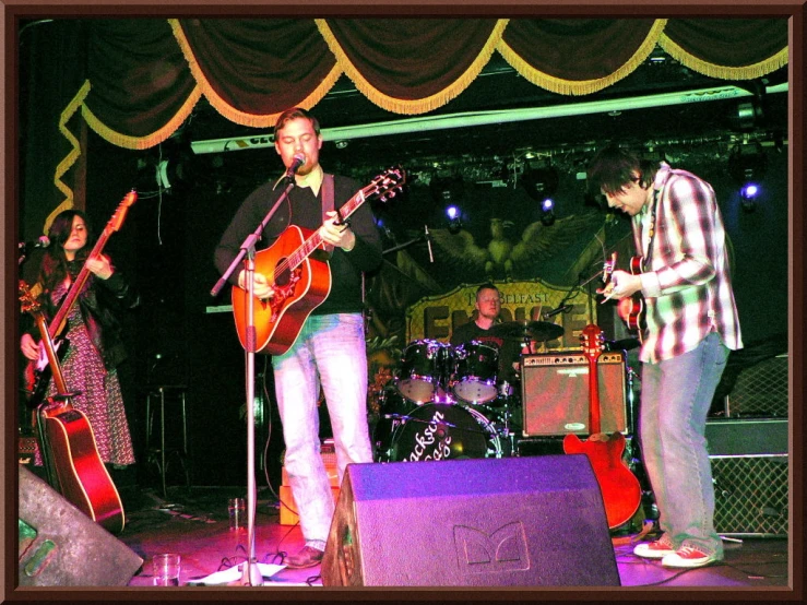 several people playing guitar on stage during a show