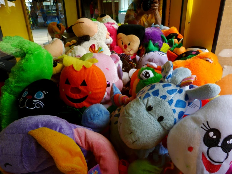 a pile of various stuffed animals sitting on the floor