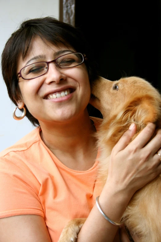 a woman smiles as she holds her dog