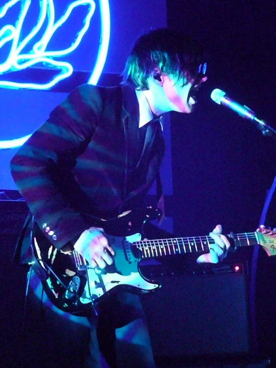 a man on stage with his guitar playing