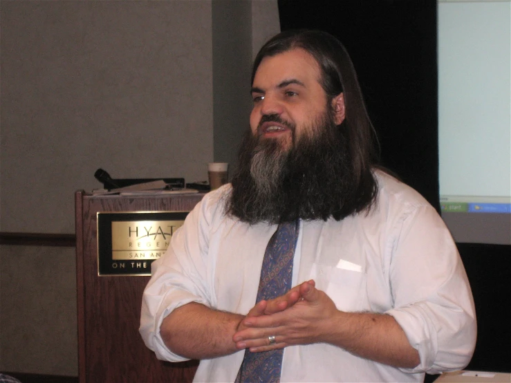 a man wearing a tie and white shirt with a beard