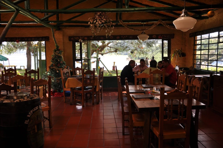 a bunch of people sit at tables in the front of a restaurant