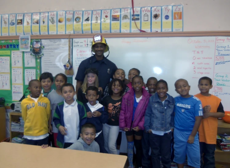 an african american man with children in a classroom