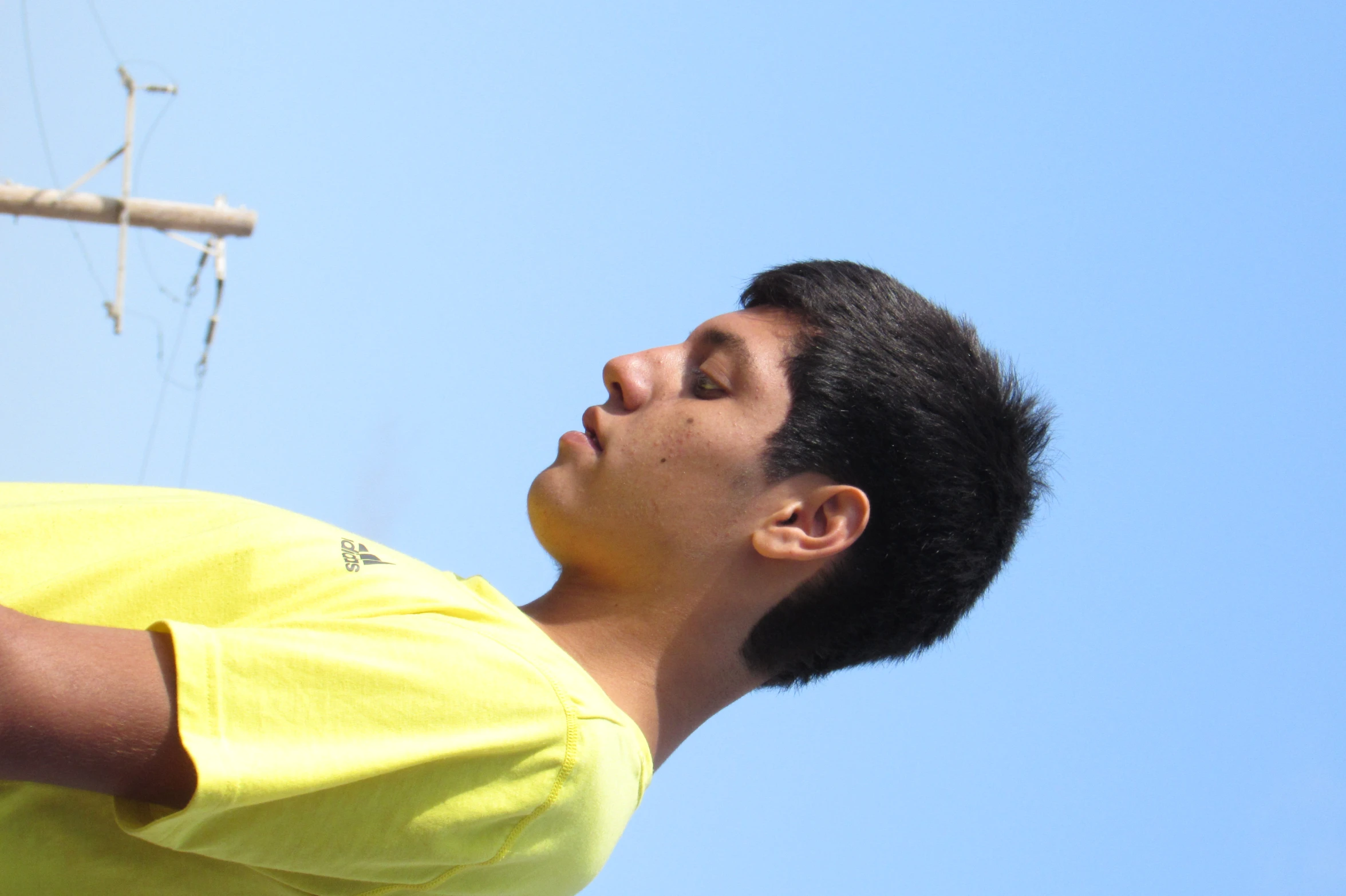 a man with a yellow shirt on and a phone