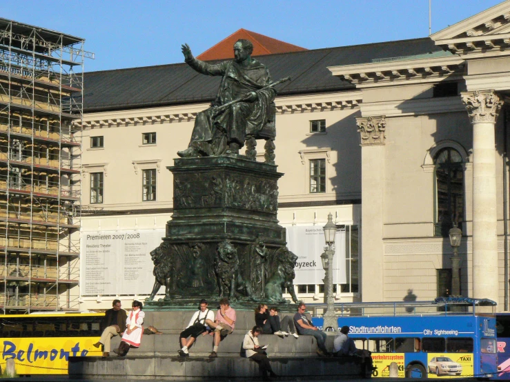 a group of people sitting around a statue