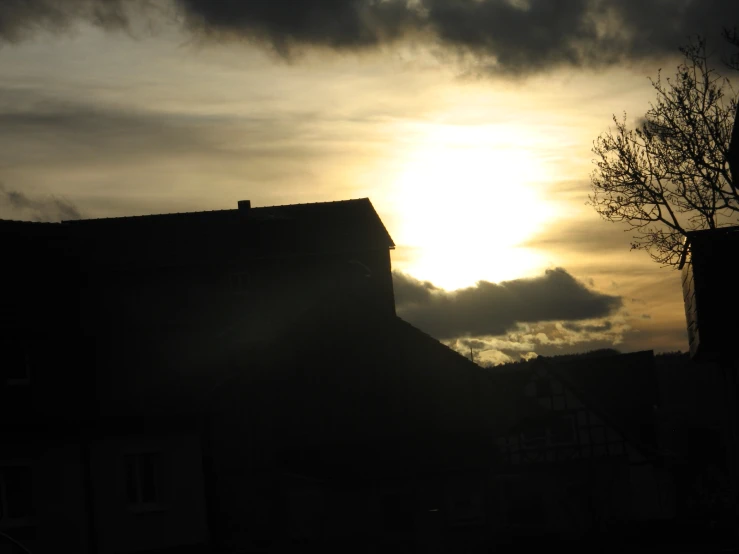 the sun is setting behind an old building