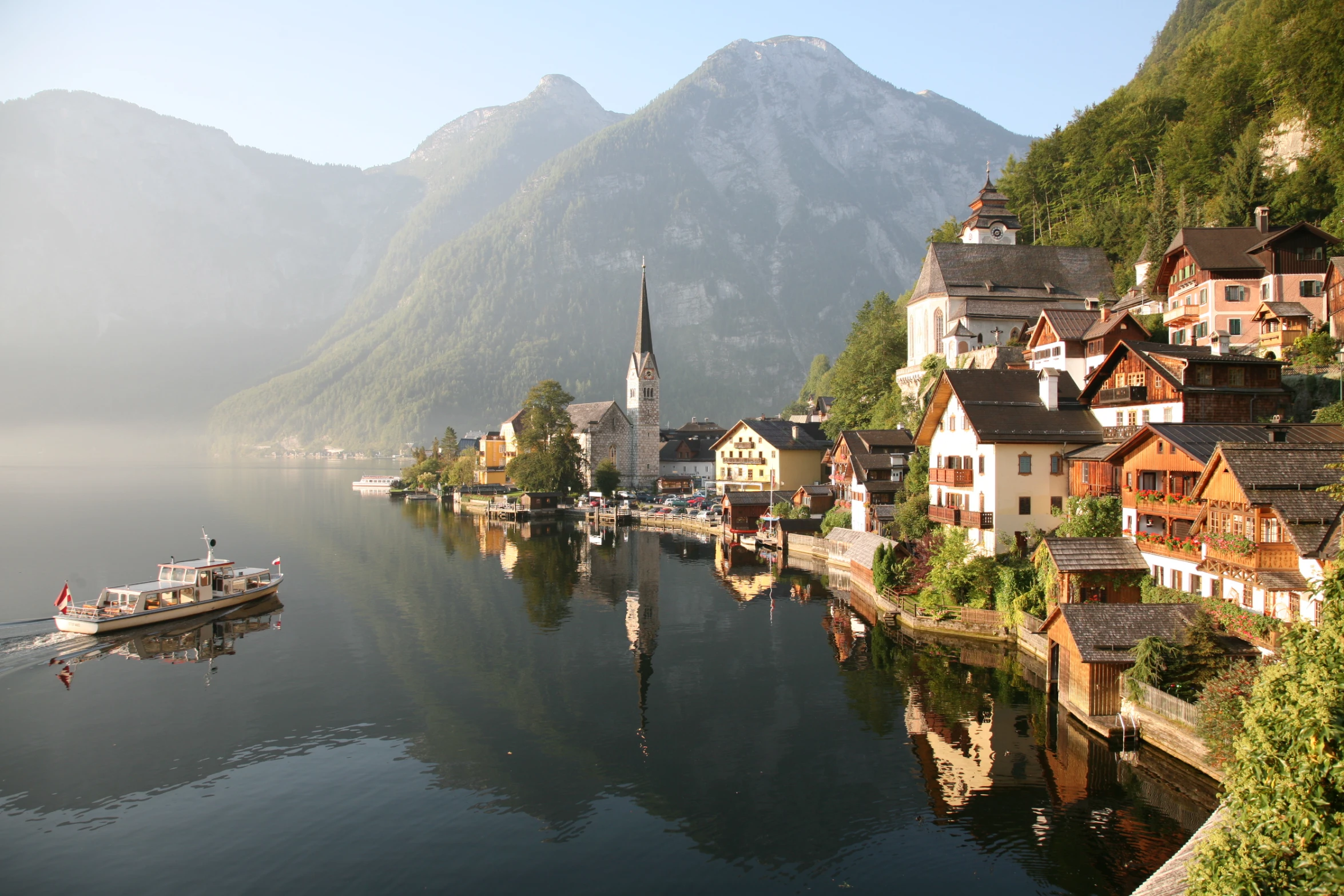 two boats sit on a calm lake in the mountains