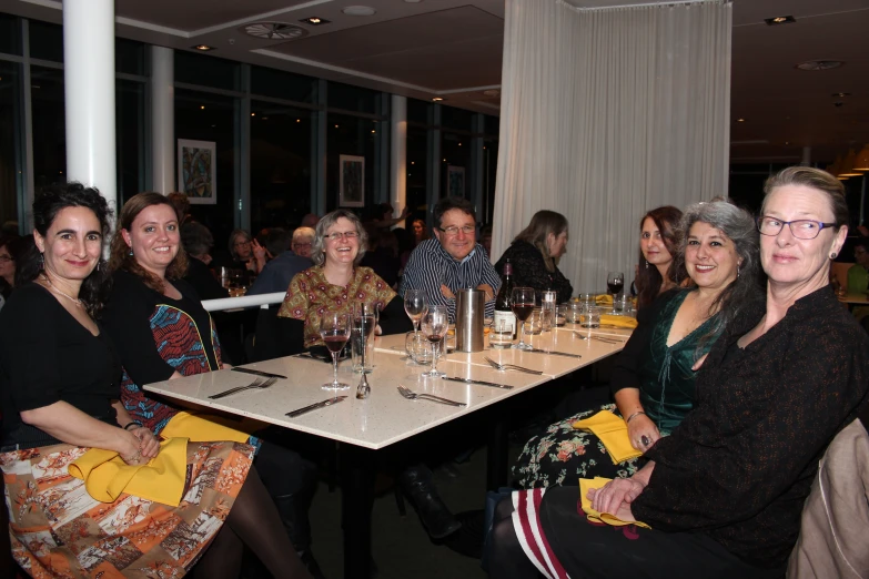 some women are smiling as they sit down for a meal