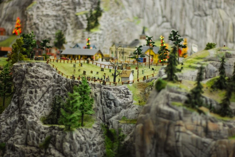 a miniature village in the mountains decorated with people and trees