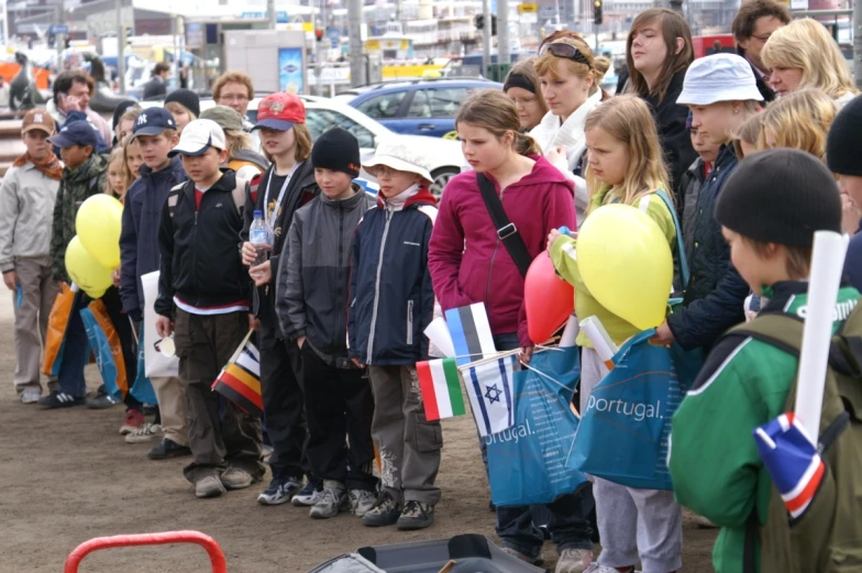 a group of young people gathered on the side of a road