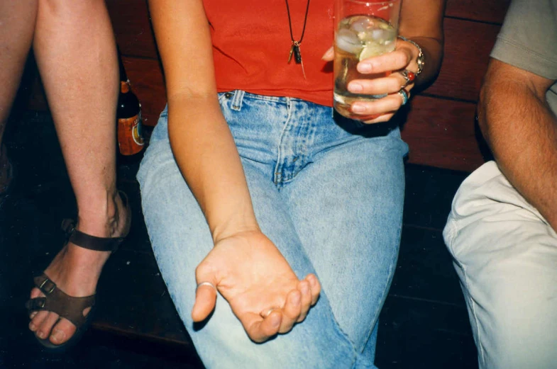 a woman holding up a glass with drinks in it