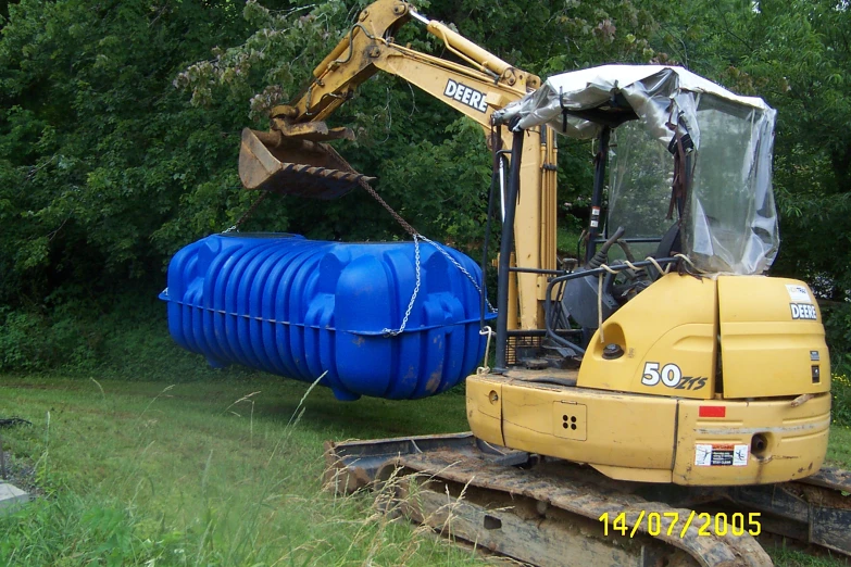 there is a very large blue barrel sitting in the back of a tractor