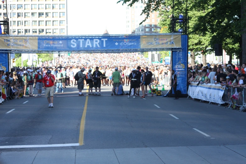 people watching and walking under an entrance to a marathon