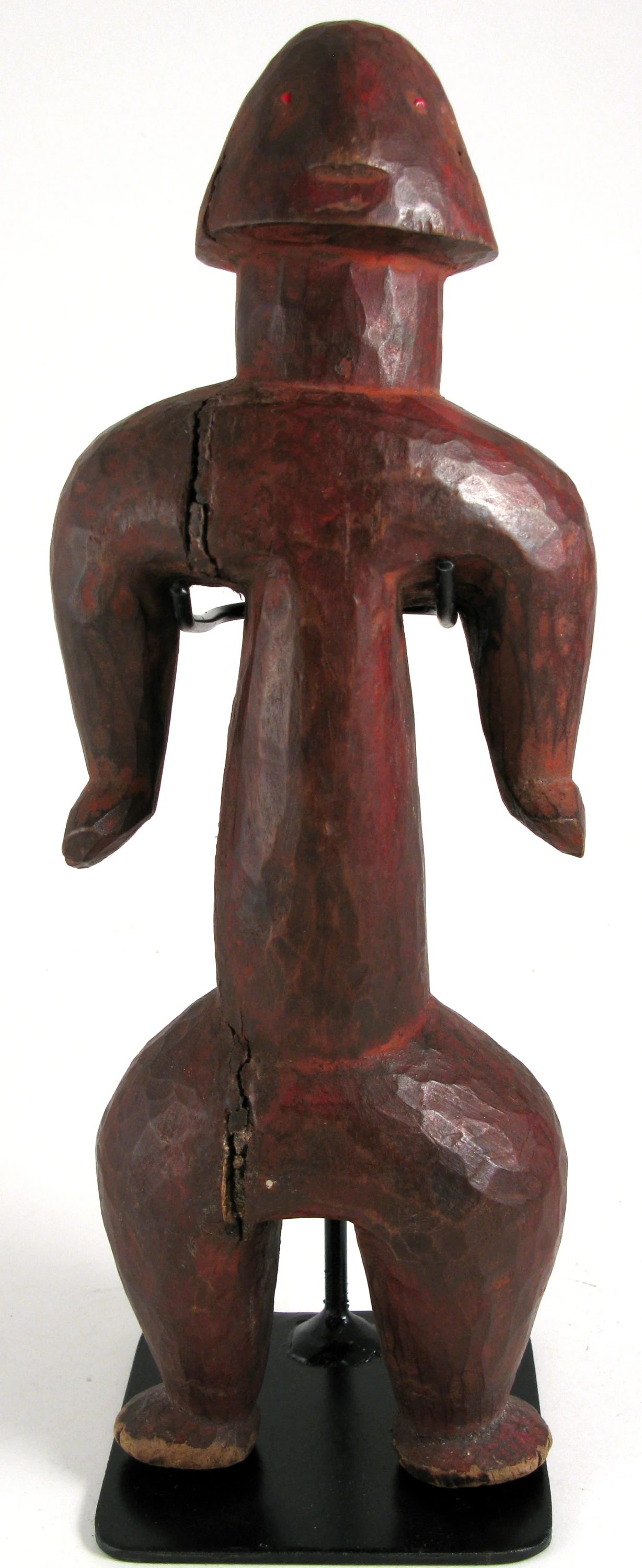 wood sculpture of man with shoulder outstretched on a black base