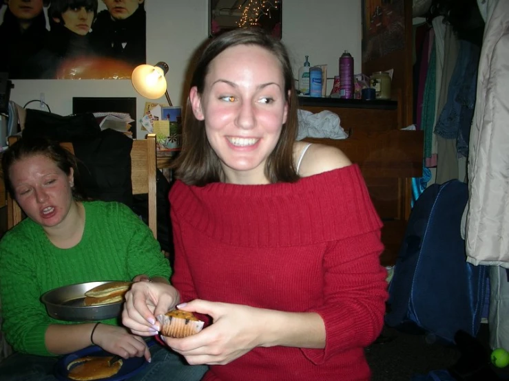 the  smiles for the camera as she holds onto some food