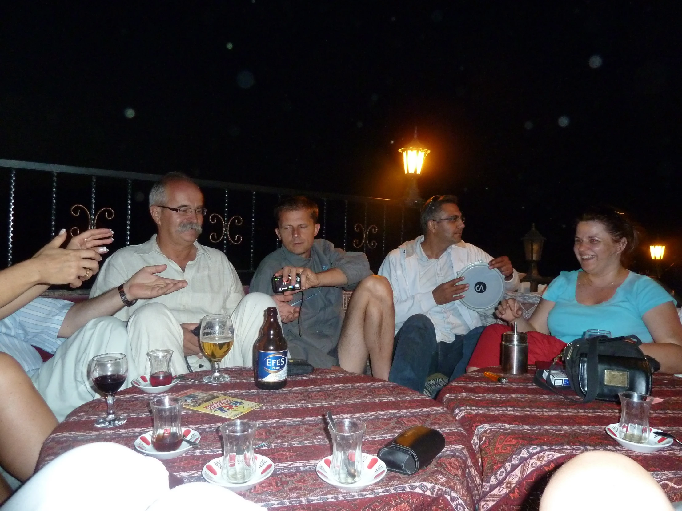 a group of people sit around a round table and have drinks