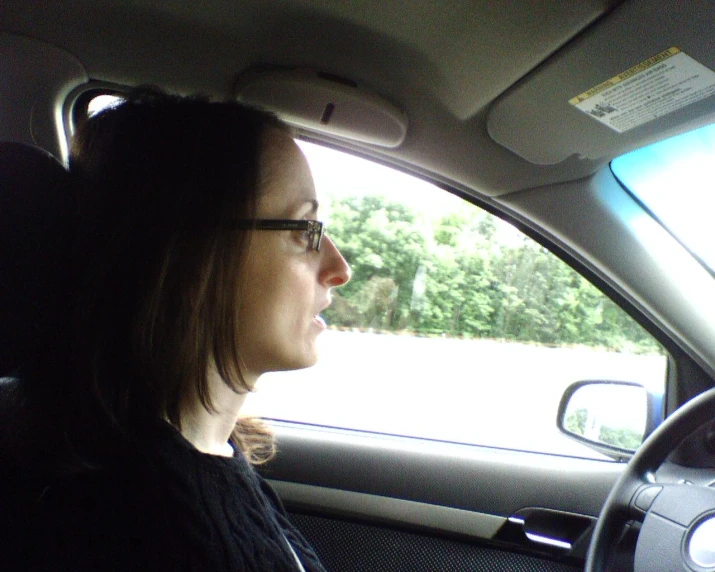 a woman sitting in the drivers seat of a car