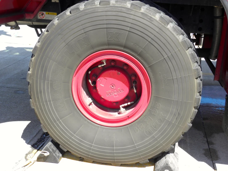 large tire on a red truck that is not working