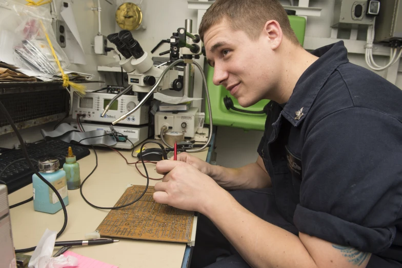 a young man in a navy shirt doing soing on a piece of paper