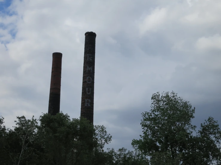 two large towers with smoke in them on a cloudy day