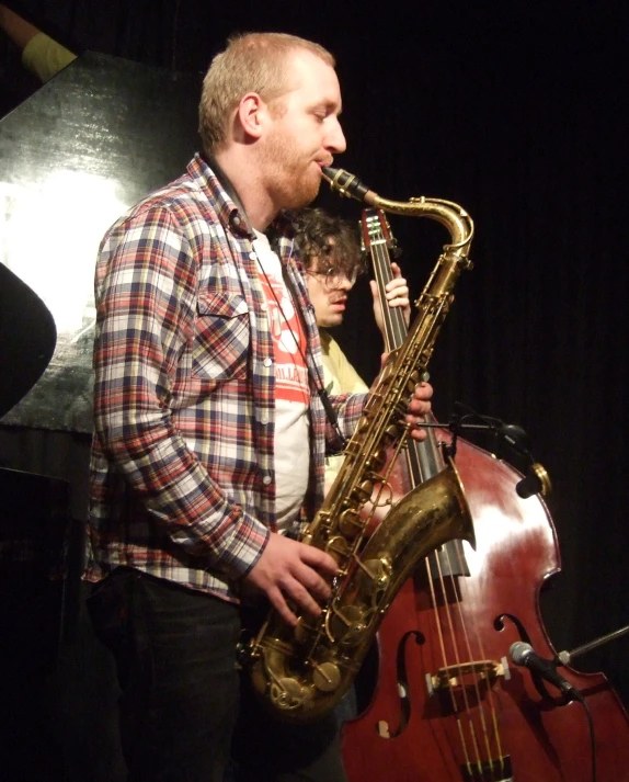 a man plays saxophone on stage at a festival