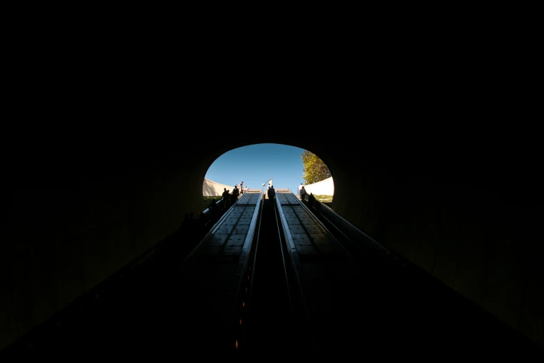 an escalator going through a dark tunnel