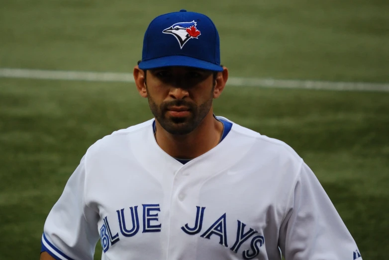 a baseball player standing next to a field