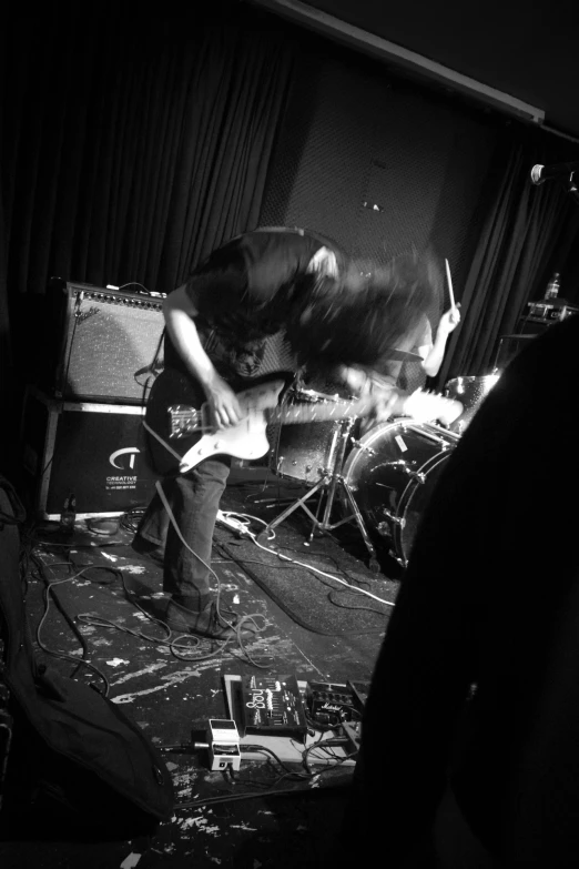 a man plays on his guitar while other people watch