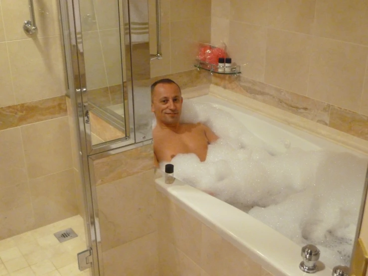 a man that is in the bathtub with foam