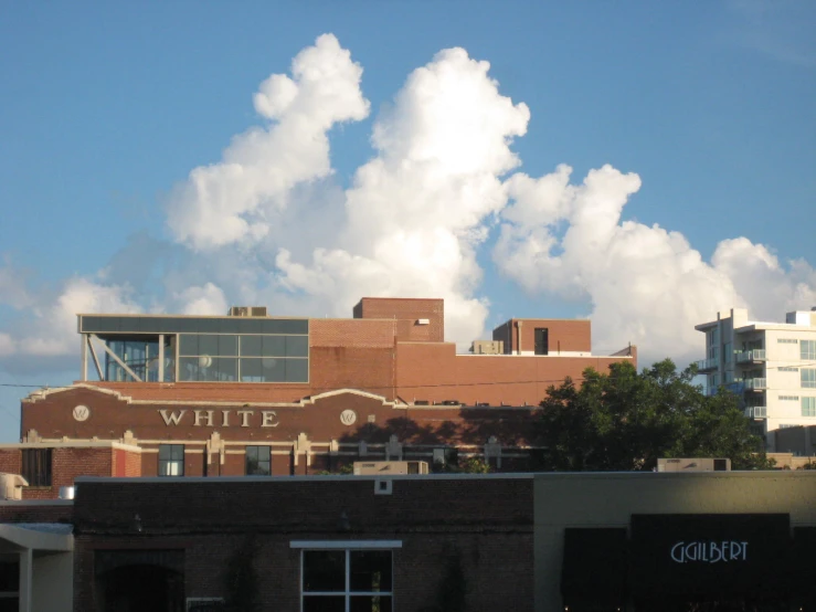 white fluffy clouds over a building in the city