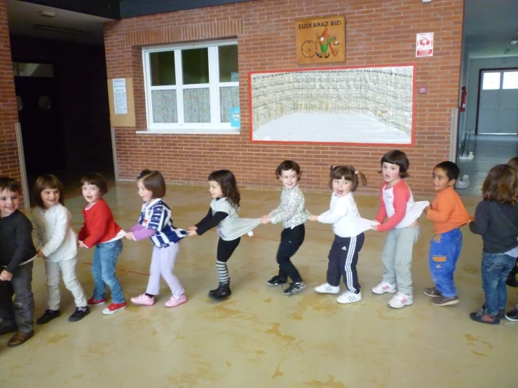 a group of children dancing in a brick walled room