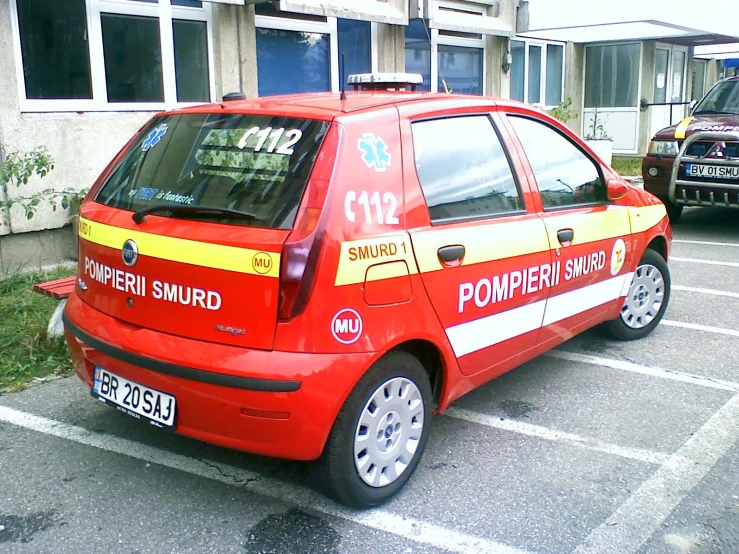 a small car with a police sign is parked in a parking lot