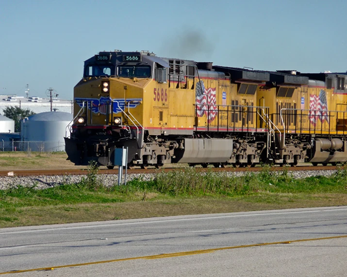 a freight train with multiple color engines going down the track