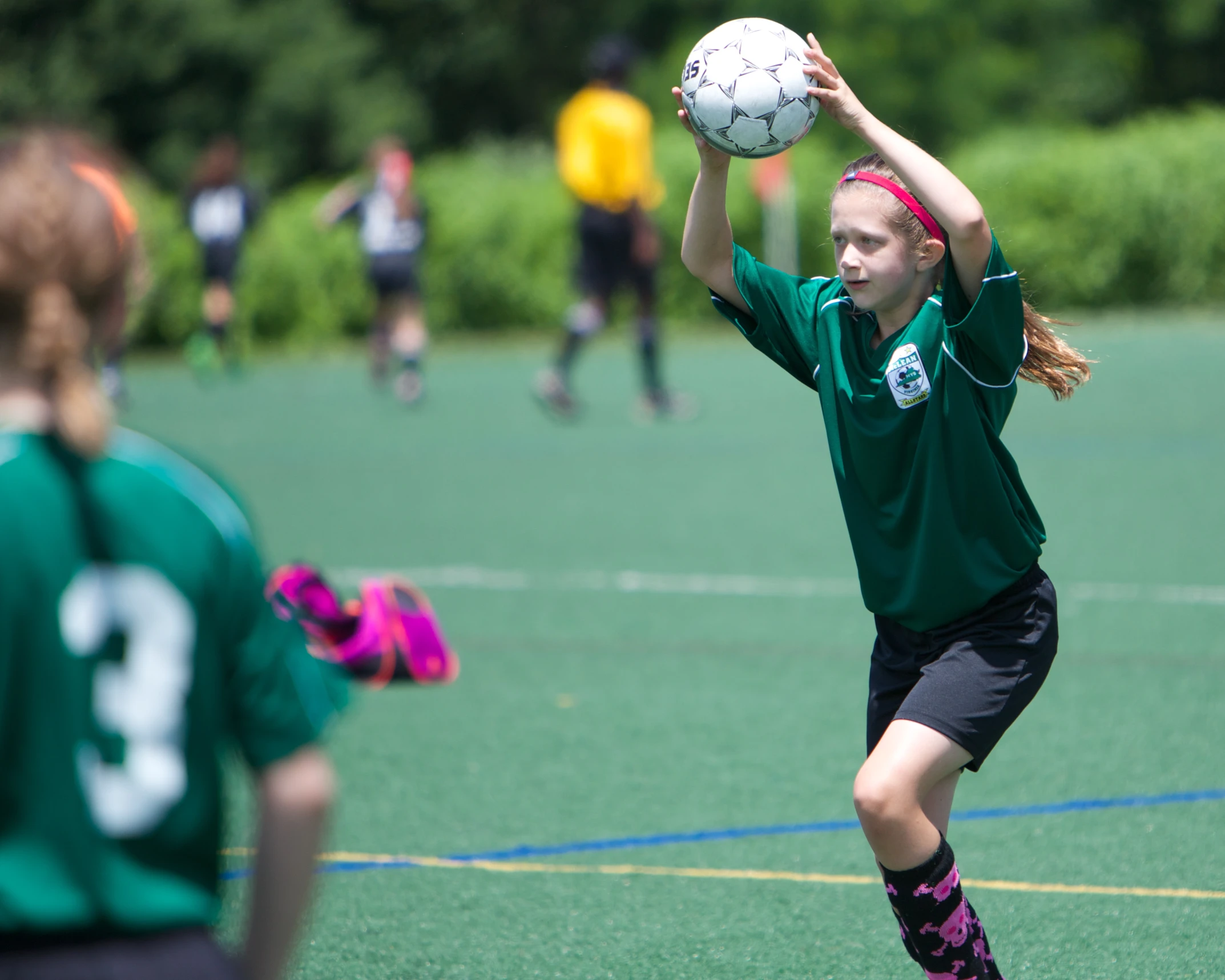 a girl about to throw the soccer ball back