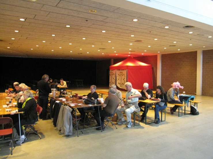 an event with a large crowd and several people sitting at tables