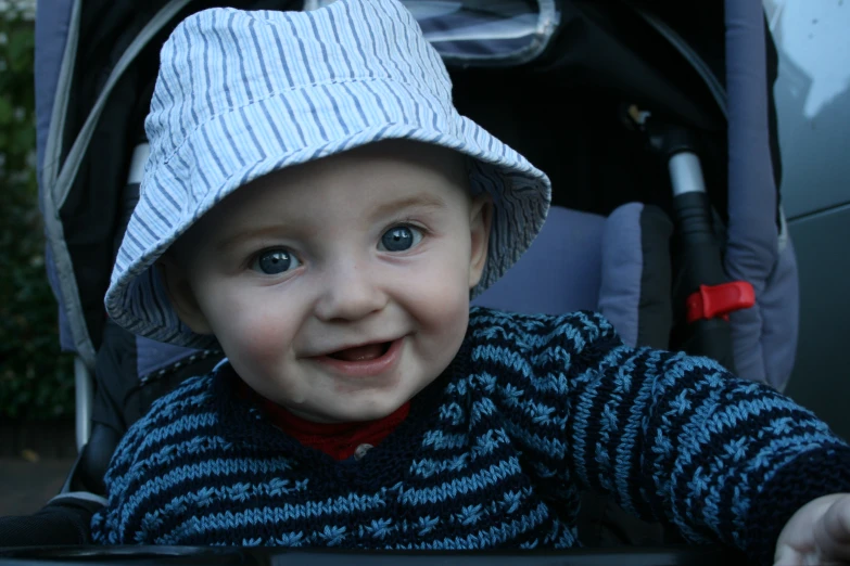 a young baby wearing a blue and white hat