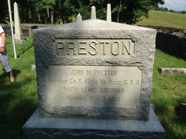 a person is standing near a monument in the grass