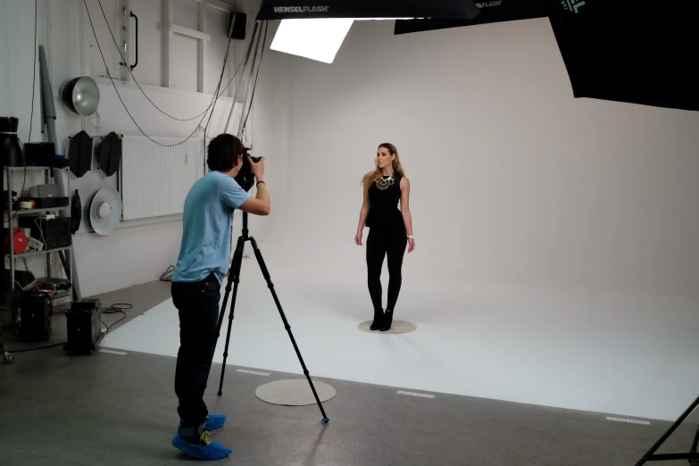 two people pose for pictures with cameras in a camera set