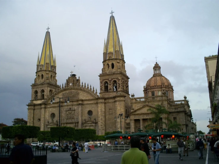 the cathedral of an old town with pedestrians in front
