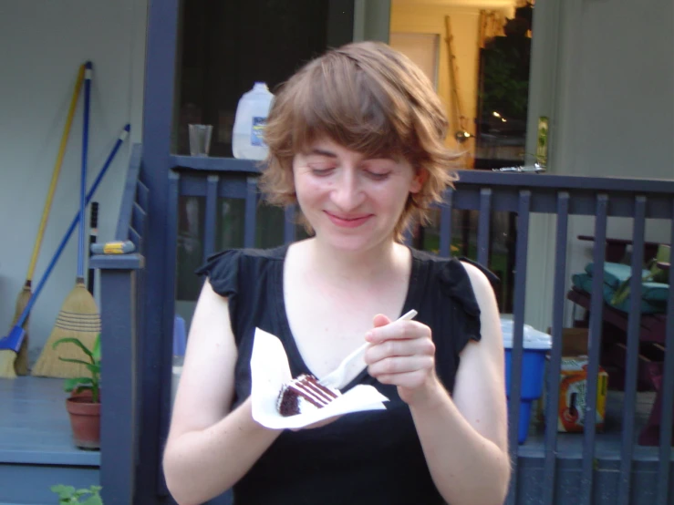 the young woman is eating cake from a plate